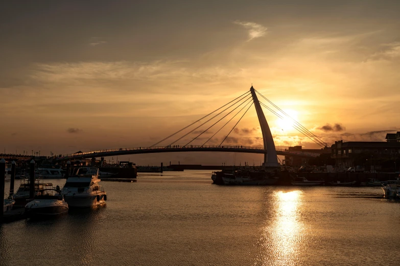 a bridge in the sky and some boats on the water