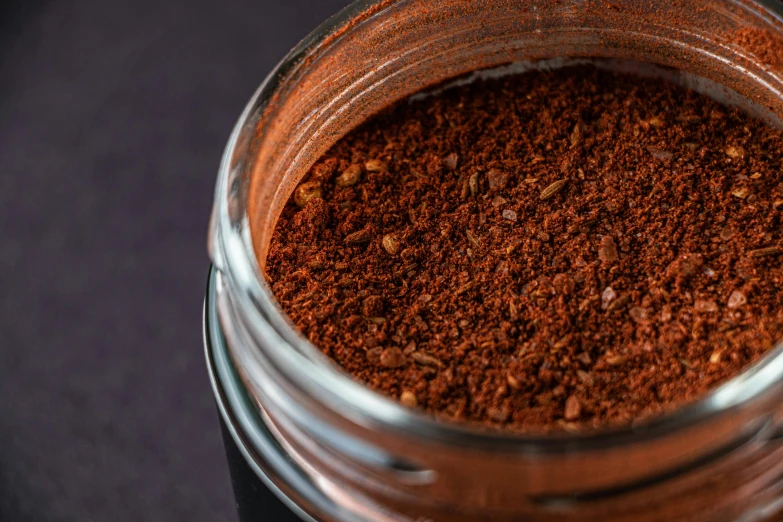 a jar filled with ground coffee on top of a table