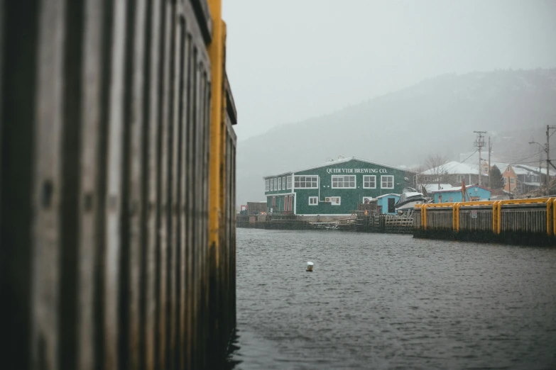 a boat docked next to a green and yellow building