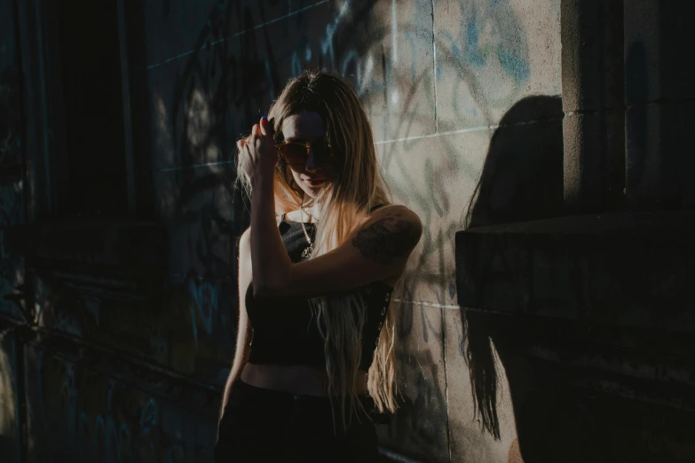 a girl wearing a tank top posing near a building