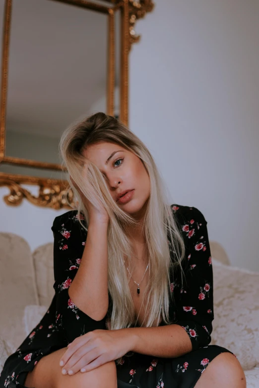 a pretty blonde woman sitting on top of a couch