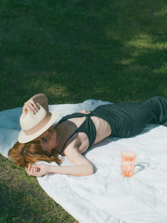 a woman with a straw hat rests on a towel