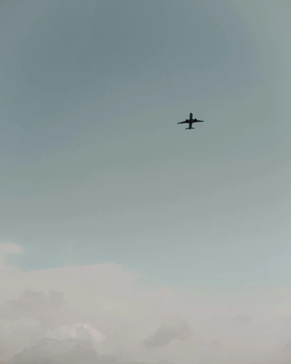 an airplane flying in the sky with white clouds