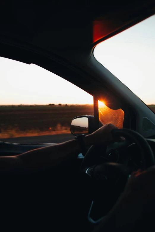 the view from inside of a car as the sun goes down