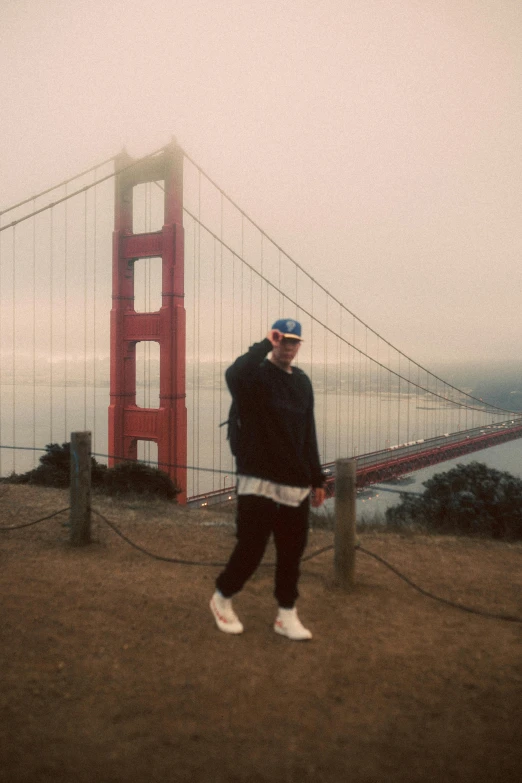 a man standing next to a tall bridge