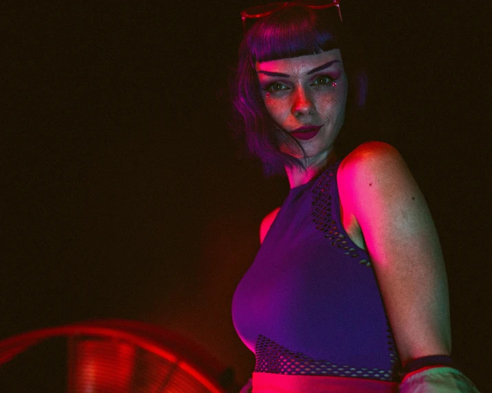 a woman posing in front of a neon colored fan