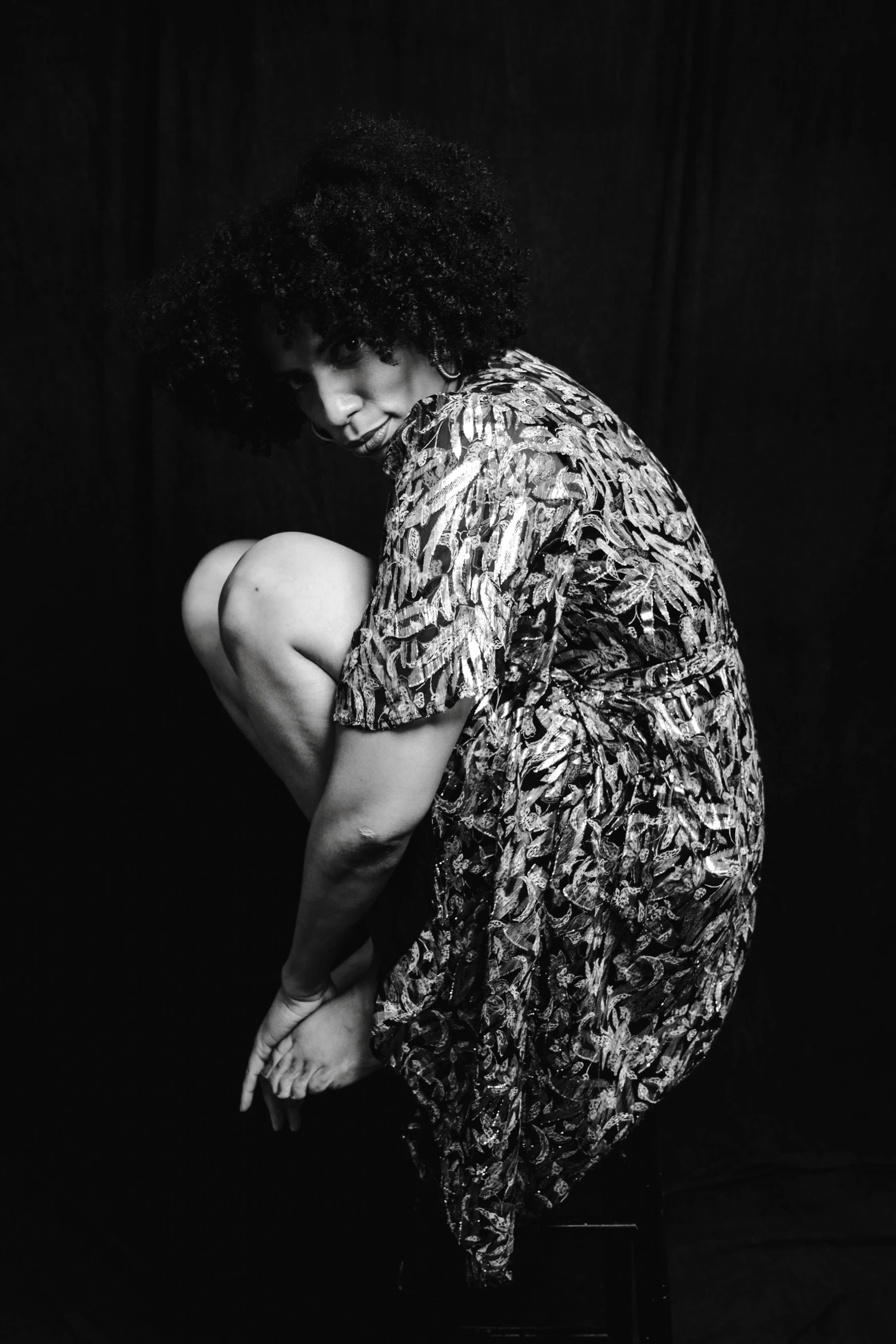 a girl leaning on a stool looking down