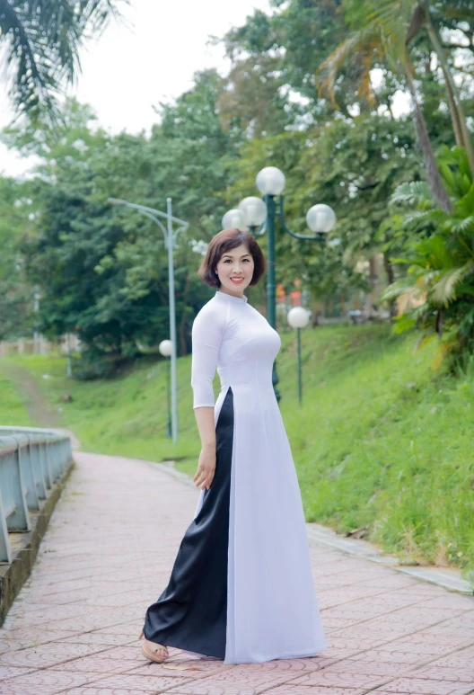 a woman posing for the camera in front of a green park