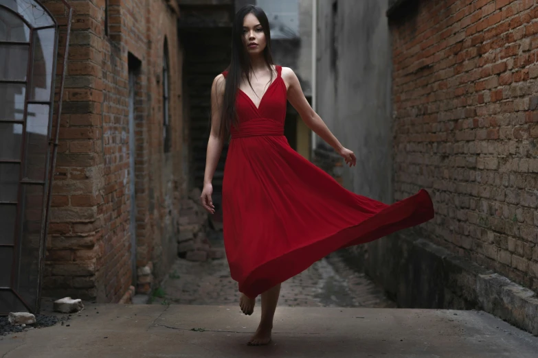 a beautiful woman in a red dress walking down a street