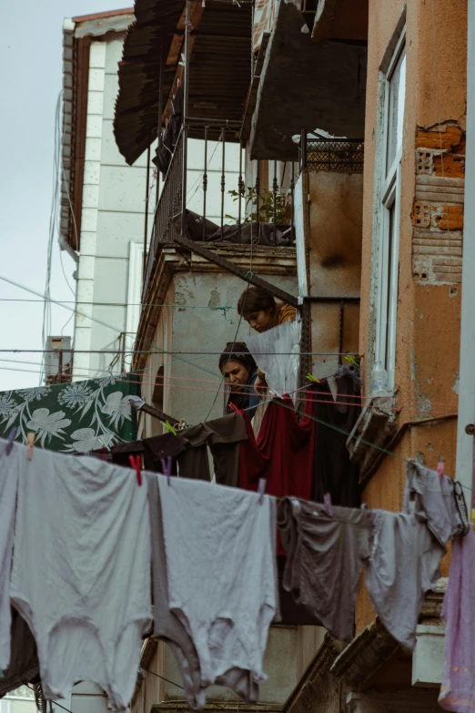 a person that is standing near clothes on a line