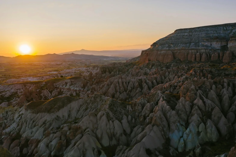 a valley at sunset with rocks and trees all around