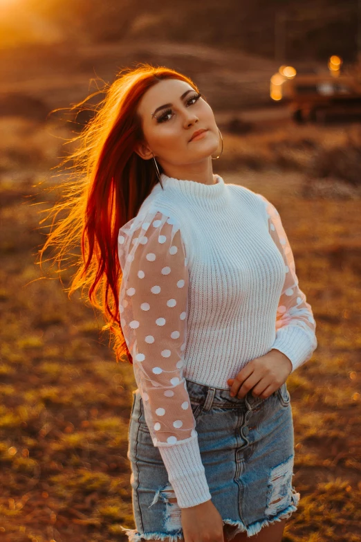 a woman with red hair is standing in the sun