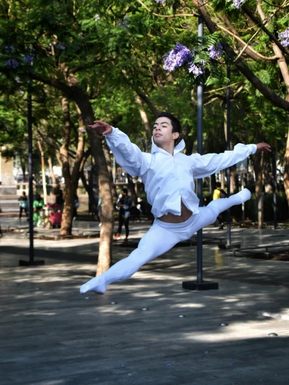 a man is performing an acrobatic maneuver on a street corner
