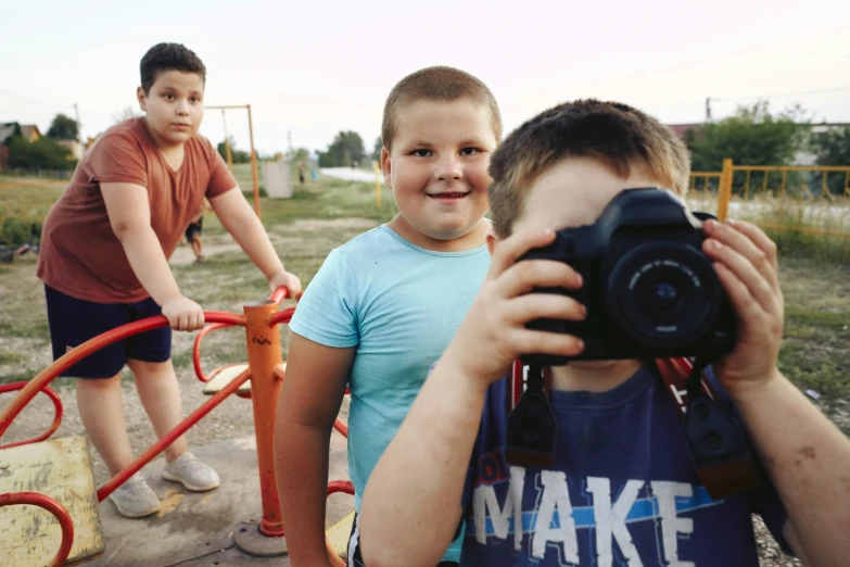 a boy is holding up a camera to take a po