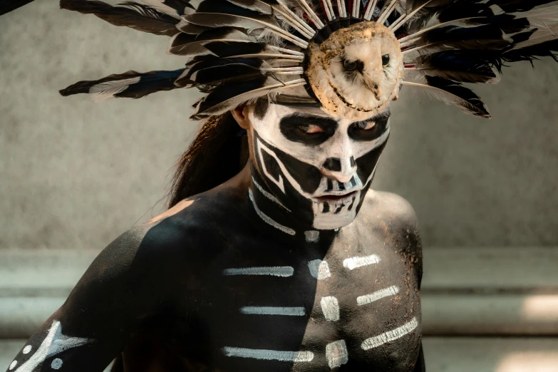 a man with dark makeup and white body painted