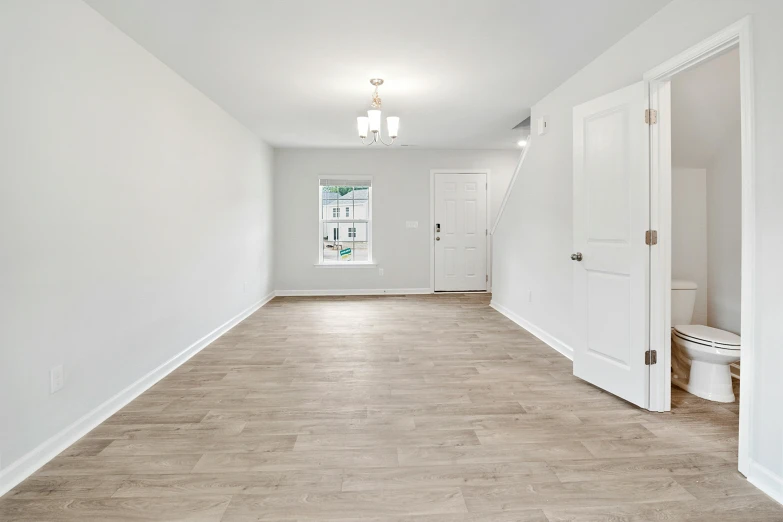 the empty bathroom has a very long hallway