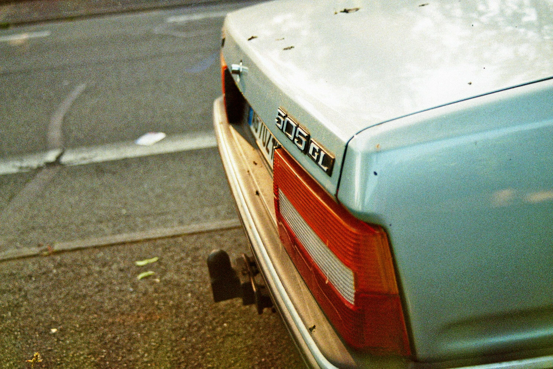 a rear bumper and part of a parked car