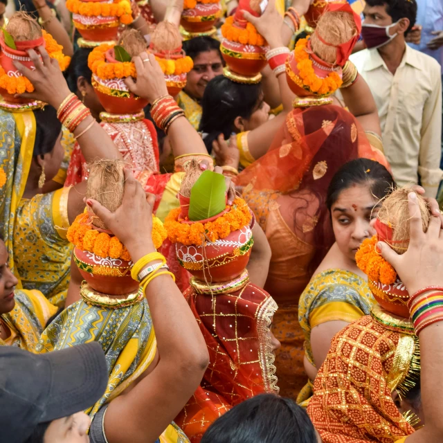 people dressed in brightly colored clothing holding up pots