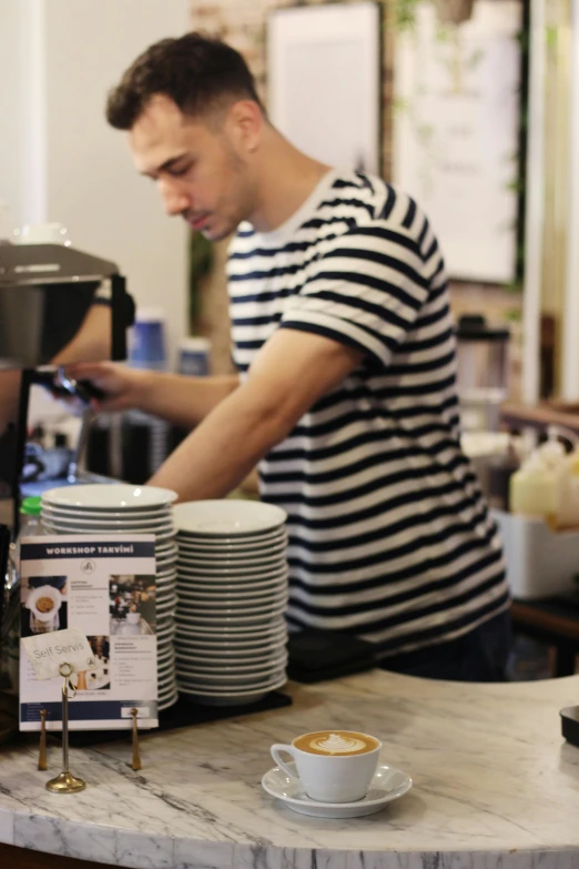 a man using a coffee maker while standing at a counter