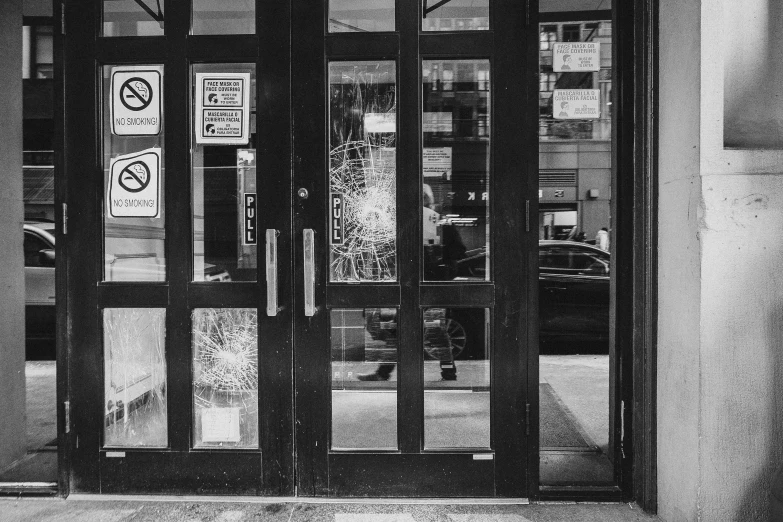 a black and white image of a door with a street sign on the outside