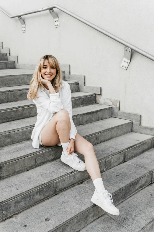 blonde girl wearing sneakers and a white shirt posing for the camera