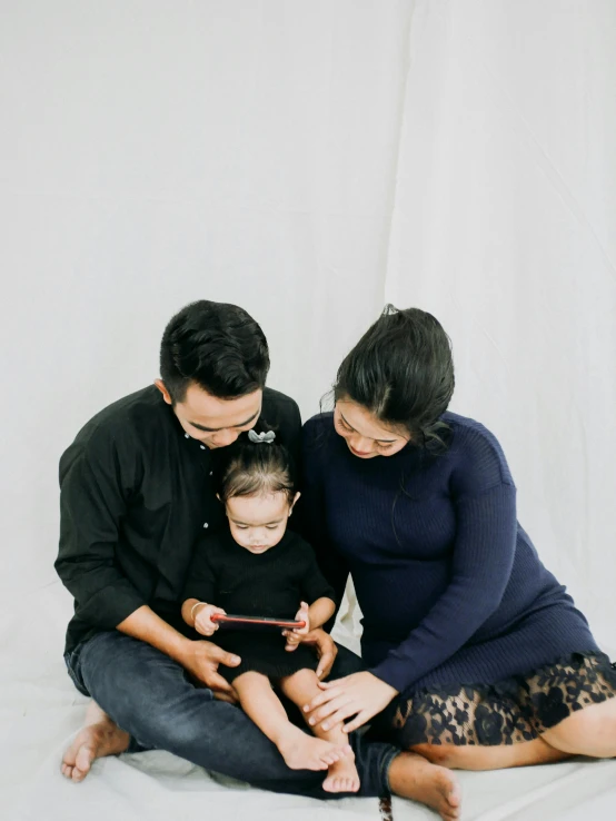 a family on a white background posing for a po