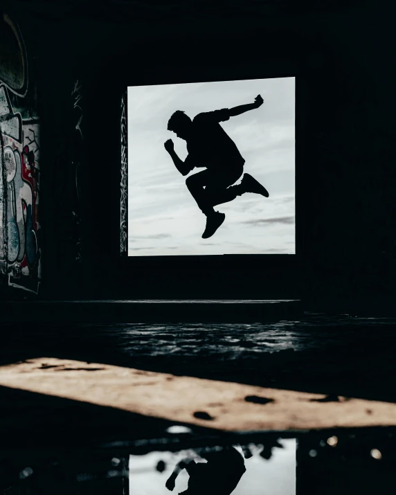 a man jumping a skateboard into the air in front of a window