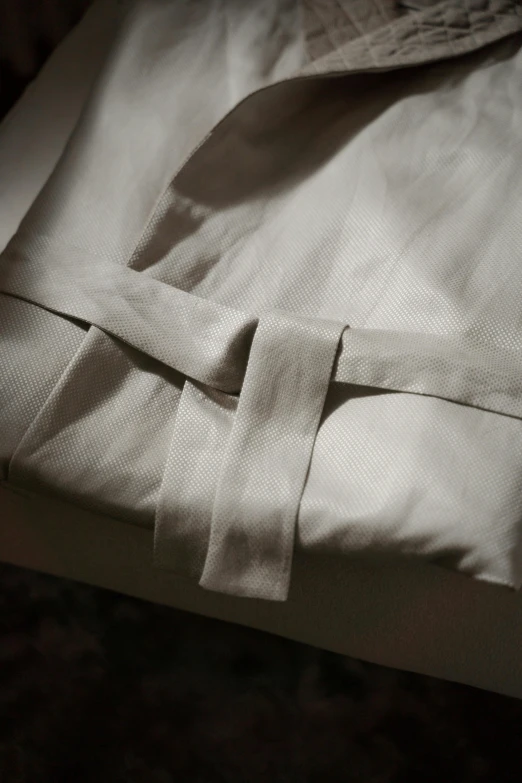 a white shirt with a knoted neckline on the bottom of it