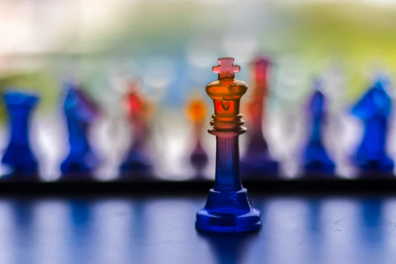 small orange and purple chess piece near several colored ones