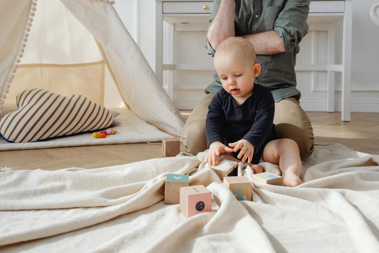 man playing with his baby on the floor