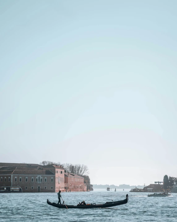 a person riding a boat in the water near buildings