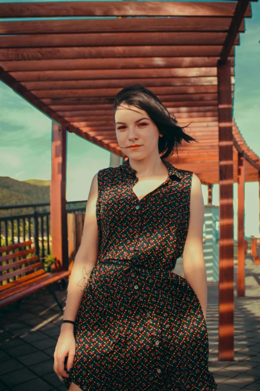 woman in black dress walking by wood structure