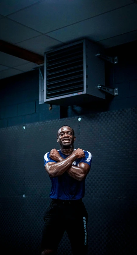 a man with his arms folded standing in front of a basketball hoop