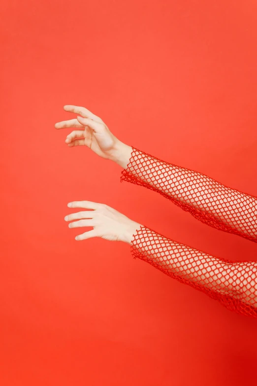 hands with wrist garters holding on to red background