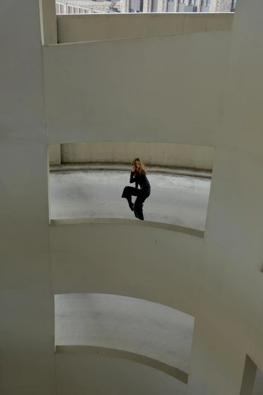 a woman is sitting on the edge of a building and talking on her phone