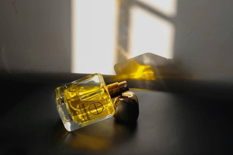 a cigarette resting on a table next to an open bottle of perfume