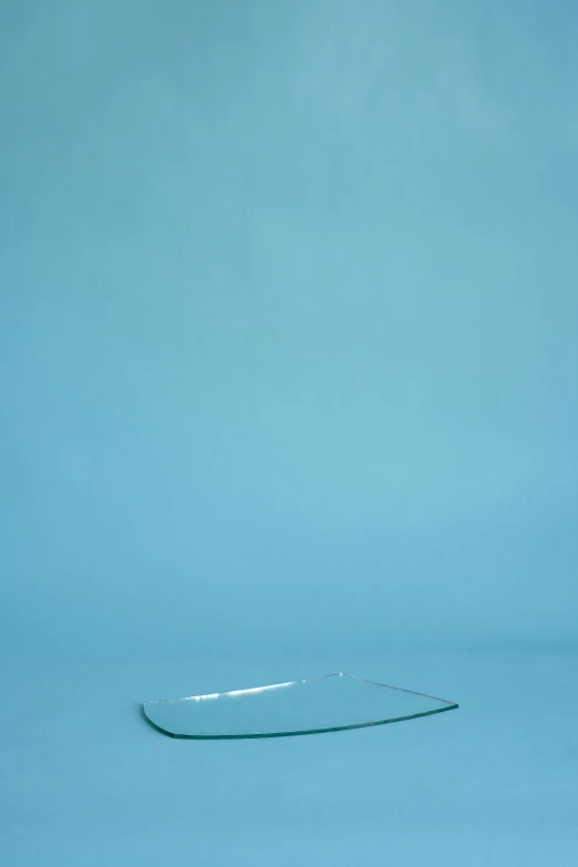 a small rectangular shape glass plate against a blue background