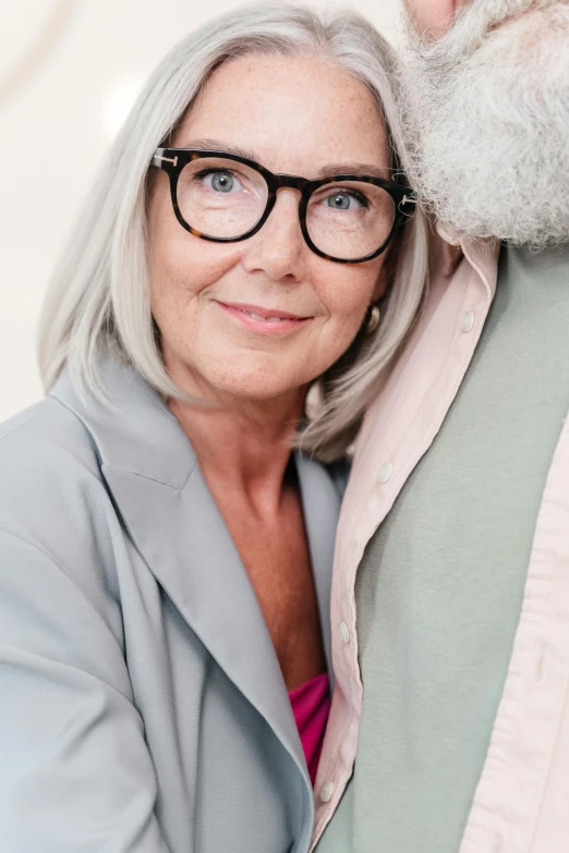 a man in a gray blazer standing next to an older woman