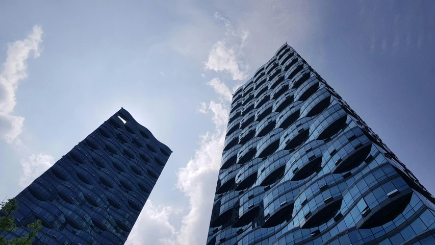 a couple of tall blue buildings with windows