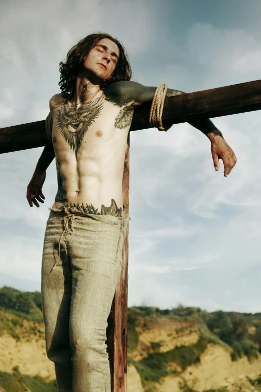 a man wearing an unusual piece of clothing holding a cross