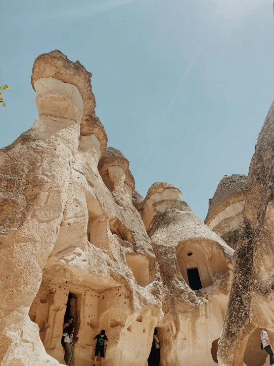 people are standing on a small hill in a large rock formation