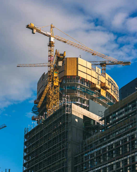 construction crane and building under construction, with tall skyscr in the background