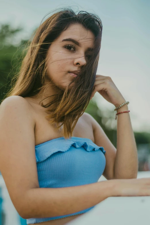 a woman in a blue top poses for the camera