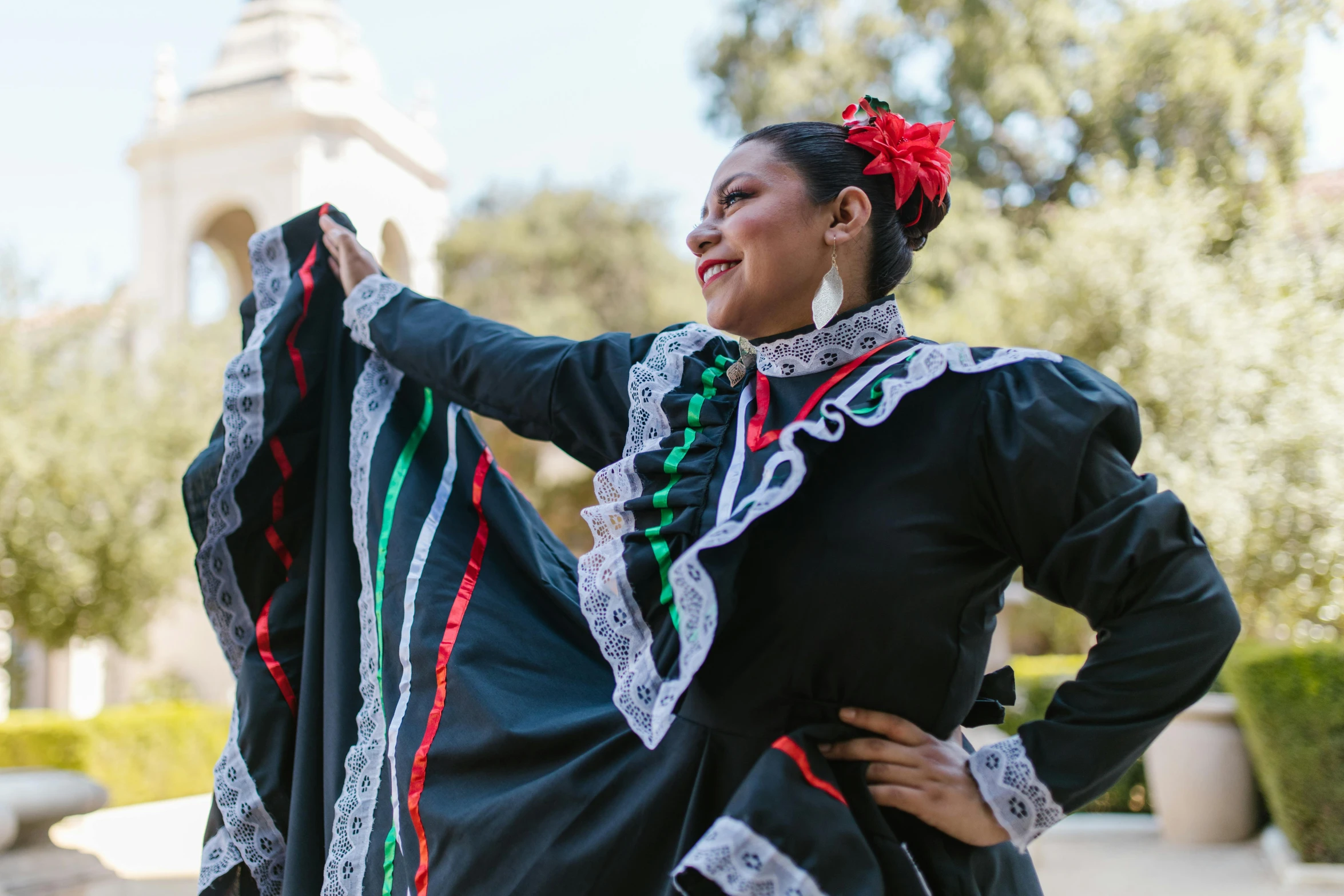 a woman in an elaborate mexican dress with her hands on her hips