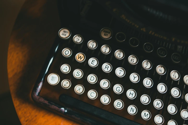 old typewriter with keys and ons showing, sitting on a table