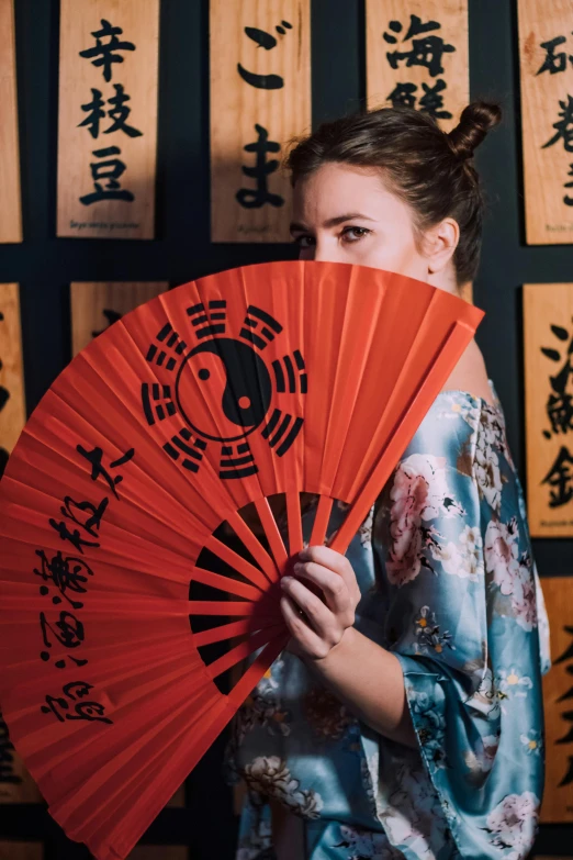 the asian girl is wearing a red traditional fan