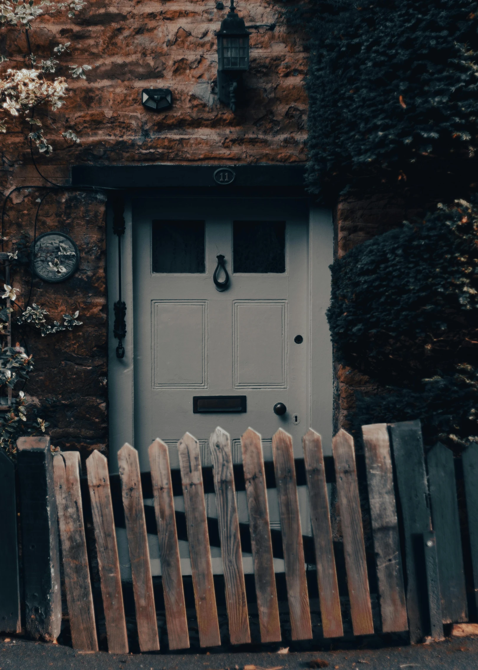 an old building with a white front door and a brown picket fence