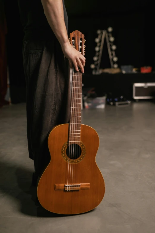 a person holds a guitar in a dark room