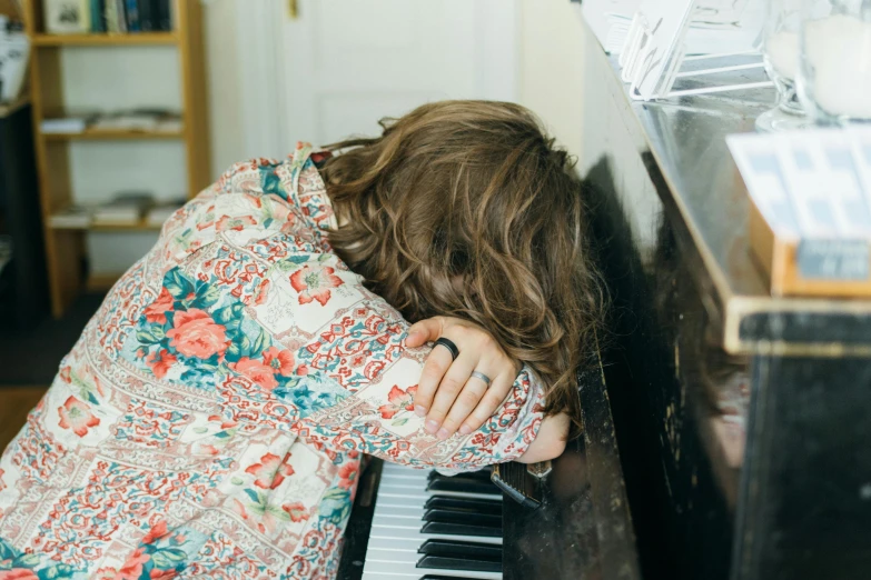 a woman sitting in front of an open piano