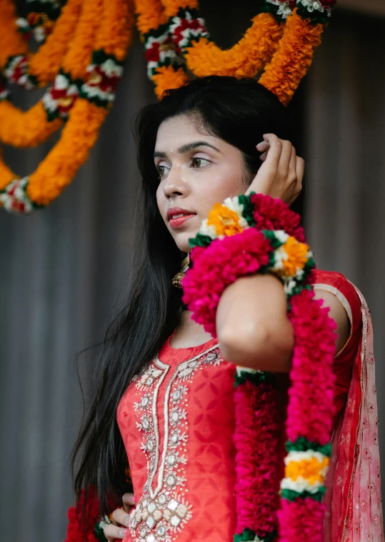 a woman in traditional dress holding flowers on her head